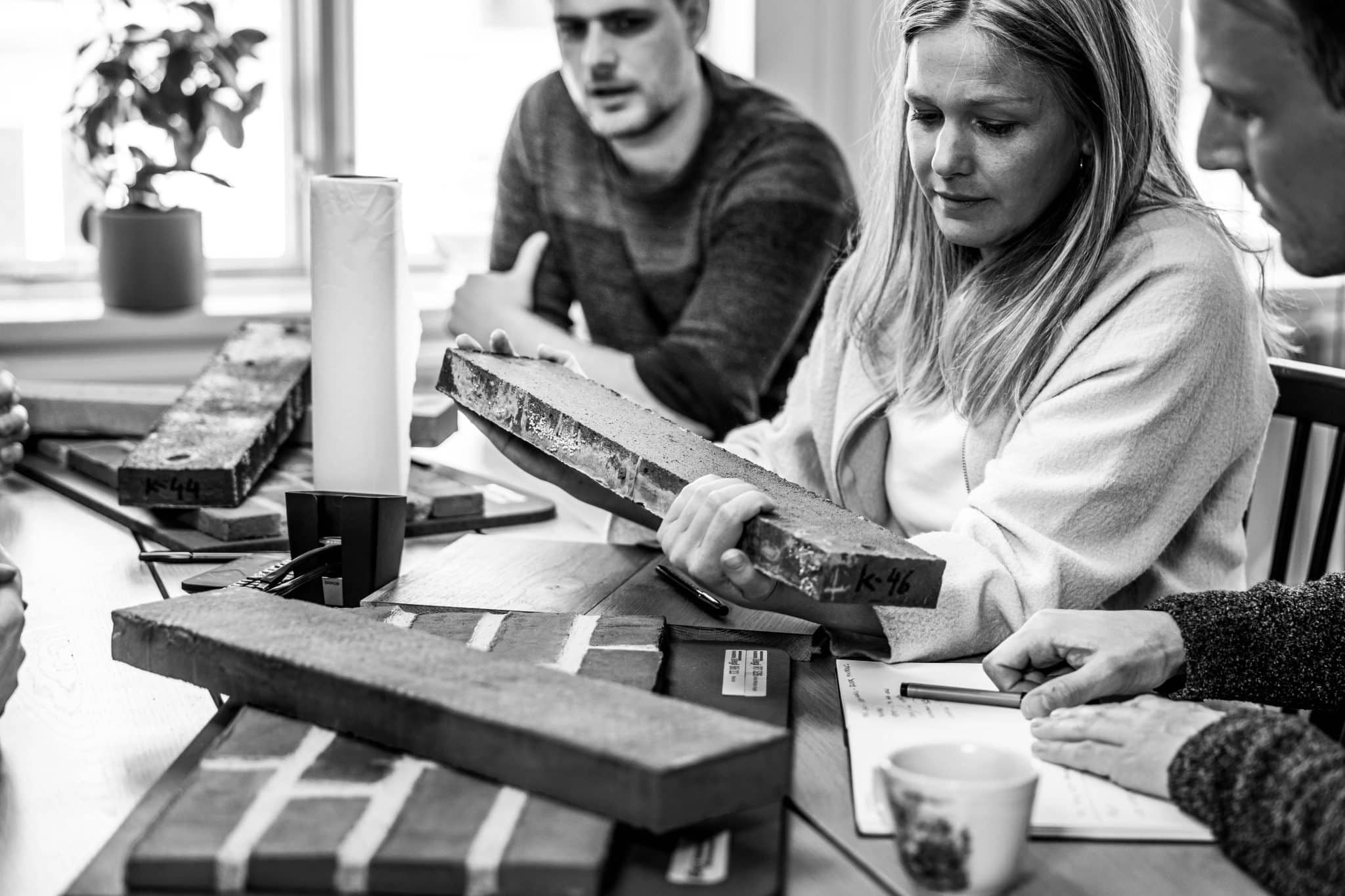 Personer som tillsammans sitter och diskuterar materialprover.